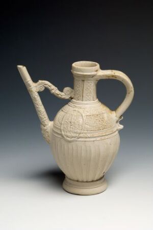  An off-white ancient-style ceramic pitcher with vertical fluting on the body, decorative embossing, and a single handle, against a soft grey background. Artist name and title are unknown.