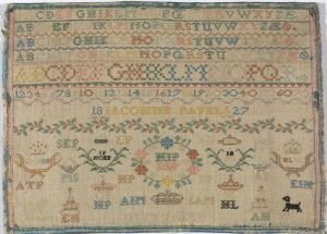  An antique embroidered sampler with rows of alphab