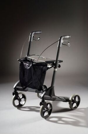  A rollator by Topro, with a lacquered metal frame and nylon bag, showcased on a gradient background. It features metallic silver handles with rubber grips, and four black rubber wheels.