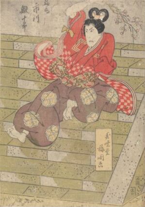  A traditional Japanese woodblock print by Seishichi Hon'ya titled "Ichikawa Ebijûrô i rollen som Fukumaru," featuring a kabuki actor seated on a patterned floor, dressed in a dramatic red and white checkered kimono and brown patterned hakama, with a stylized white face and traditional hairstyle, against a muted background adorned with Japanese script.