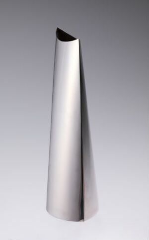  An asymmetrical, metallic cone-shaped object with a brushed silver finish, standing against a gradient gray background. Artist name and title are unknown.