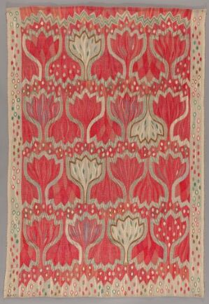  A vibrant handwoven tapestry titled "Rød Crocus" by Ann-Mari Forsberg, featuring a repeating pattern of stylized red and pink crocus flowers with a contrasting light border decorated with small geometric shapes.