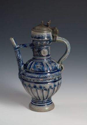  A blue and white ceramic teapot with intricate patterns and designs, featuring a curvy handle and an upward-angled spout, set against a soft grey background.