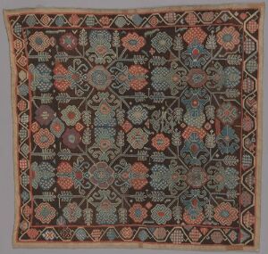  A square textile featuring detailed geometric and floral patterns in a symmetrical design, using earthy tones of deep oranges, blues, and browns, with a dark star-shaped figure at the center, surrounded by interlocking hexagons and octagons, bordered by narrow bands with smaller repeating patterns.