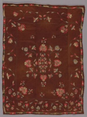  An intricately designed floral textile with a rusty brown background, featuring a symmetrical pattern of off-white, pink, and green flowers and leaves, suggesting a traditional craft origin. Artist name and title are unknown.