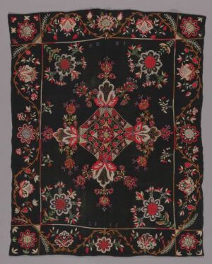  A traditional oriental-style textile with a symmetrical pattern featuring a central diamond-shaped medallion on a dark background, surrounded by a dense border of red, pink, and green floral motifs.