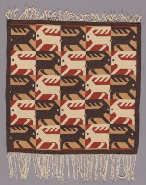  A handwoven tapestry with a brown background displaying a repeating pattern of stylized bird-like figures in white, umber, and black, bordered with a white fringe on the ends.