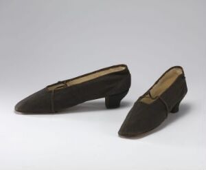  A pair of vintage women's pointed-toe shoes in deep chocolate brown, possibly velvet or suede material, with the insole of one shoe visible, on a light grayish background.