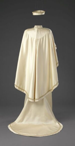  A regal, floor-length ivory cloak with a raised circular collar displayed on a mannequin against a neutral background, with subtle variations in the fabric's color highlighting its flowing, elegant design.