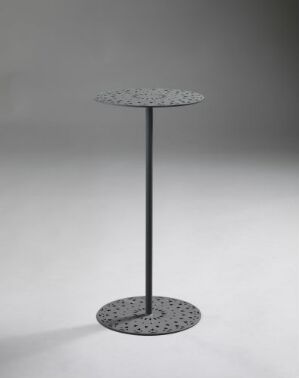  A modern circular metal table with intricate laser-cut patterns on the top and base, presented in a monochromatic dark shade against a neutral background, designed by Maria Förster.