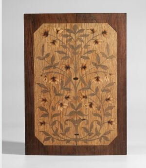  An intricately designed rectangular wooden panel with a dark brown frame and a floral marquetry design on a lighter brown background, featuring symmetrical flowers and foliage.