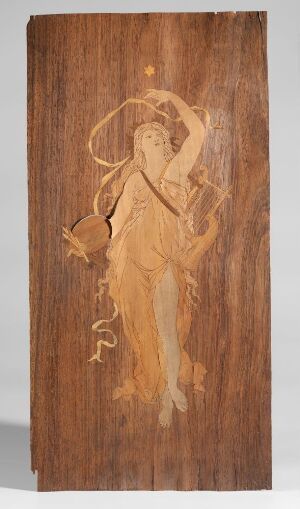  A wooden panel with an artful etching of a female figure in a dancing pose, surrounded by intricate designs in varying shades of brown, showcasing traditional woodworking craft. Artist name and title are unknown.