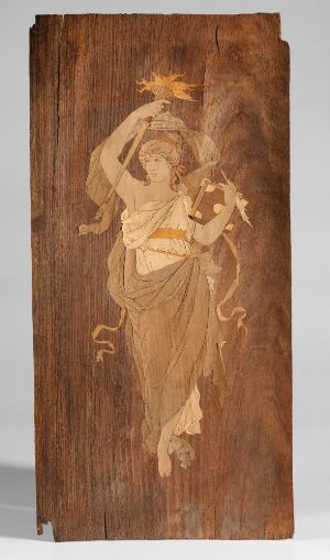  An artwork of a female figure depicted in relief on a rectangular wooden panel, possibly created using wood-burning or inlay technique, with the figure holding a flame above and a flute extended outward, all in a lighter hue against the dark background of the wood grain. Artistname and title are unknown.