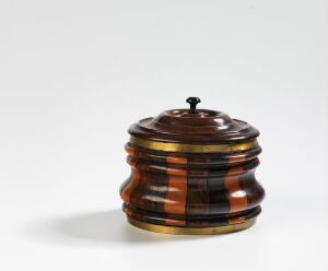  A small wooden container made from layers of various brown-toned woods with a striped pattern, featuring a barrel-like shape and a dark handle on the lid against a white background. Artistname and title are unknown.