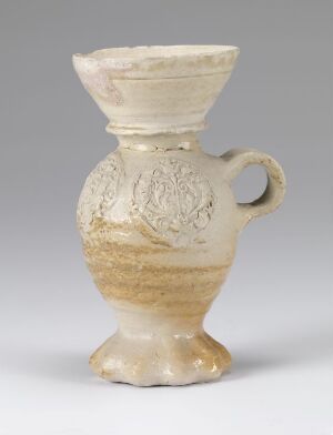  A small antique-looking ceramic jug with a flared base, bulbous body with textured floral patterns, a narrow neck, and an off-white flared rim. It has a single handle and an organic beige and brown color scheme. Artist name and title unknown.