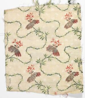  Vintage fabric with a repeating pattern of stylized crimson flowers and green leaves connected by curving green vines on an off-white background, showing signs of wear and slight fraying at the edges.