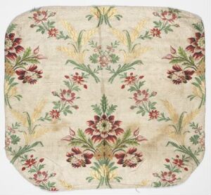  A square piece of fabric with rounded corners, showcasing a symmetrical floral pattern with a dominant central flower in dark pink and crimson, accompanied by mirrored arrangements of smaller flowers, slender green stems, and leaves on a cream background.