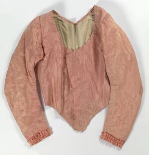  An antique salmon pink blouse with full sleeves and a small standing olive green collar, displayed against a plain background. The garment evokes a vintage feel, possibly originating from the Victorian or colonial period.