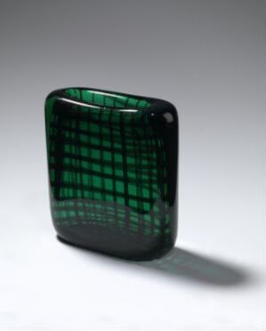  A rectangular-shaped blown glass decorative object by Hadeland Glassverk, featuring a translucent emerald green color with a consistent grid of black lines, showcased against a soft grey background.