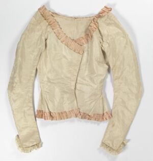  An antique off-white long-sleeved blouse with a deep V-neckline and ruffled trim detailing laid flat against a white background.