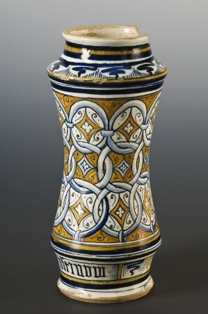  A ceramic vase on a gray background with an intricate blue, gold, and white interwoven knot pattern tapering towards the base, highlighting geometric and botanical-inspired motifs.