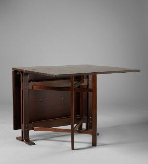  A wooden table with a rectangular top and rounded corners, supported by four tapered legs, with a lower shelf in a darker wood finish against a plain light grey background.