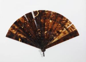  A handheld folding fan with a tortoiseshell-like pattern, in various shades of brown and translucent amber, displayed against a white background.