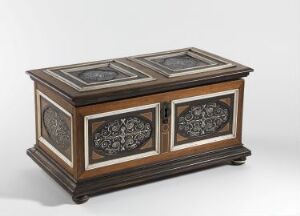  An antique wooden chest with intricate inlay work, featuring a flat top with two decorative panels and front doors with ornate openwork designs, set against a light background.