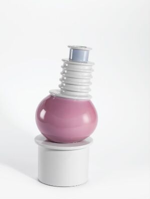  A porcelain decorative object on a white background, featuring a cylindrical white base, a matte pink spherical body at the center, and a white, threaded neck resembling a bottle top or light bulb base. The piece is støpt and glasert, with no given artist name or title.