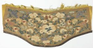  An embroidered arch-shaped fabric with a dense floral pattern, predominantly in soft peach, creamy yellow, pale blue, and various shades of green on a pale taupe background, bordered with a solid darker edge and yellow-gold fringe at the top.