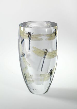  "Libelle," a blown glass art piece by Cathrine Maske, featuring delicate encapsulated dragonflies with green and yellow-tinted wings within a clear, vase-like object.