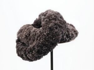  An object that looks like a grey fluffy cloud is mounted on a slender black stand against an off-white background.