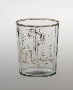  A decorated transparent glass with floral etchings standing against a soft white background.