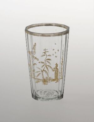  A clear glass with a detailed, gold-colored nature-inspired design featuring leaves, branches, and an insect, likely meant for use as drinkware.