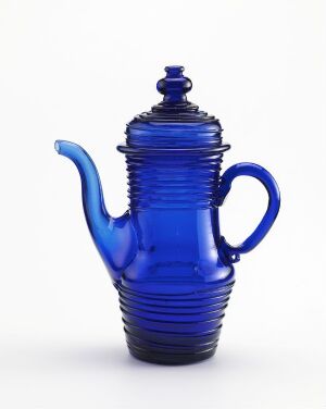  A vibrant cobalt blue teapot with horizontal ridges and a glossy finish, featuring a curved spout and handle, set against a plain background.