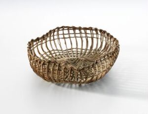  A beige porcelain bowl titled "Trådkurv beige" by artist Sidsel Hanum, featuring an open, woven design with delicate porcelain strands creating a basket-like structure, set against a white background.