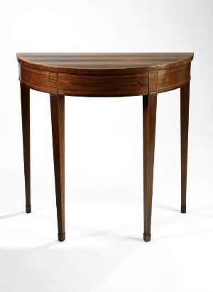  Antique demilune table with a flat back and half-moon shaped front, featuring a rich, warm brown wooden finish with darker streaks and delicately tapered legs with metal-capped feet against a white background.