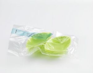  A display of "Disposable" by Anne Bannick, consisting of molded, vacuum-packed bioplastic and sugarcane fiber dishes in a translucent light green color, sealed together and set against a white background, showcasing the idea of sustainable single-use dining ware.