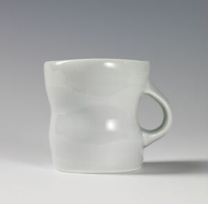  A white ceramic mug with a glossy finish and a simple, elegant design stands against a light grey background, devoid of any patterns or additional colors.