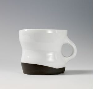  A stylish white ceramic mug with a unique ergonomic shape and an integrated handle, featuring a contrasting earthy brown band at the base against a light grey background.