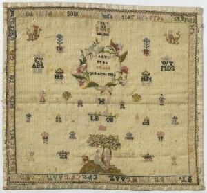  An antique square sampler with embroidered alphabets and symbols in various colors on a cream-colored cloth, showcasing intricate needlework and decorative motifs.