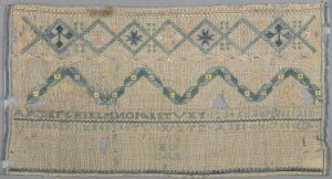  Antique rectangular textile with a beige background, featuring a repeated pattern of teal and dark blue diamonds, wavy lines, and eight-pointed stars. The fabric appears aged with frayed edges, suggesting historical significance or use.