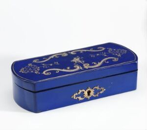  An elongated rectangular box with a domed lid, painted in deep blue, featuring gold scrollwork and floral designs on the lid and a decorative keyhole on the front, displayed against a white background.