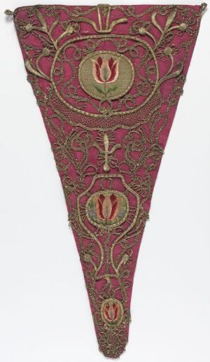  An elongated triangular ceremonial textile banner with a crimson background and gold embroidery, featuring a large circular medallion with a pink and gold floral emblem at the top, flanked by two smaller oval medallions with similar designs, all connected by gold stems and leaves.