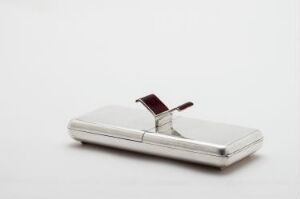  A small, silver metallic case with rounded corners and a dark red clasp, set against a pure white background.