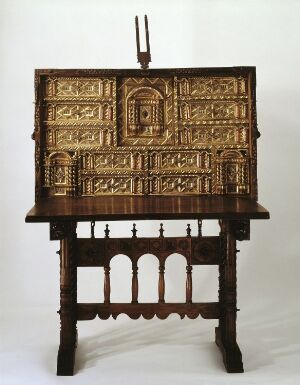  A Kabinettskap by an unidentified artist, which is a walnut furniture piece featuring carved gilded decoration on two closed doors, overlaid ironwork on velvet, interior gilding, turned and in