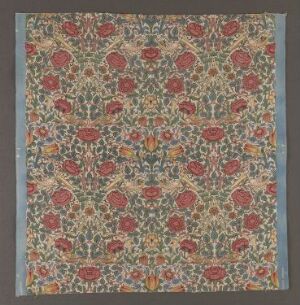  Cotton fabric titled "Rose" by William Morris with a complex, printed botanical pattern featuring red roses, blue, yellow, and white flowers on a dense green leafy background.