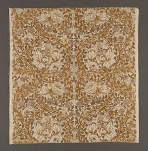  "African Marigold" cotton textile design by William Morris, featuring a symmetrical, earth-toned floral pattern on a beige background. The design combines shades of gold, brown, and tan, in a detailed, flowing arrangement of botanical motifs.