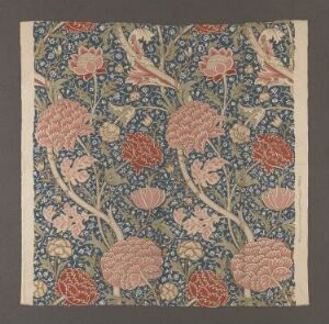  A piece of cotton textile, called "Cray" designed by William Morris, featuring an intricate pattern of winding stems and large flowers in shades of blue, pink, coral, and green on a deep blue background, exemplifying the Arts and Crafts Movement.