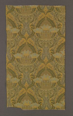  A photograph of a textured fabric or wallpaper with an ornate, symmetrical pattern in muted yellow and green tones, featuring stylized floral and geometric shapes.